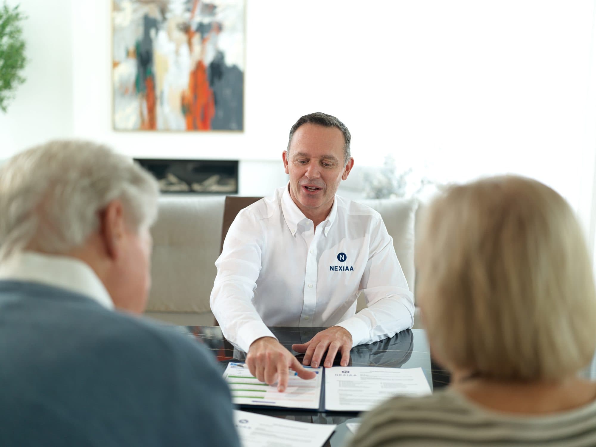 François présente une entente à des clients réunis à la table.